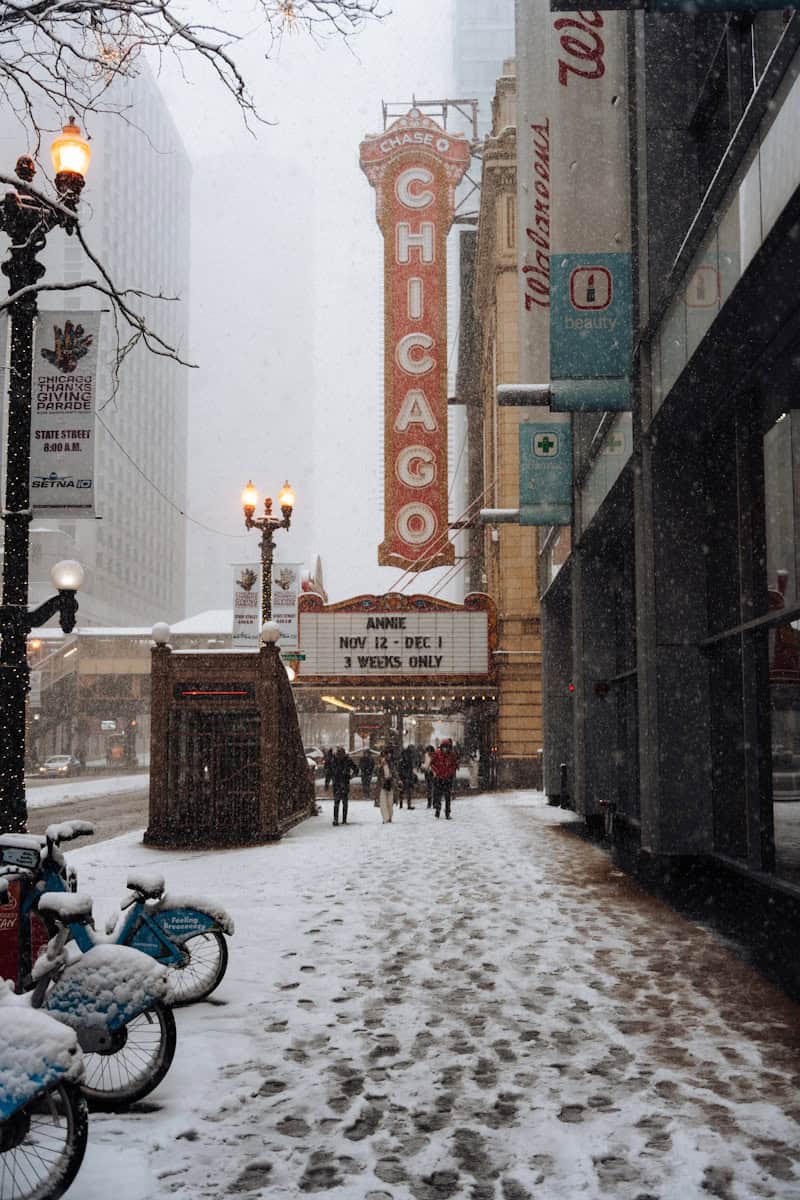 A city street covered in snow next to tall buildings